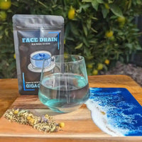 Bundle of Giga Chew Free Face Drain Herbal Tea gift packets, featuring colorful packaging and tea bags for herbal detox.